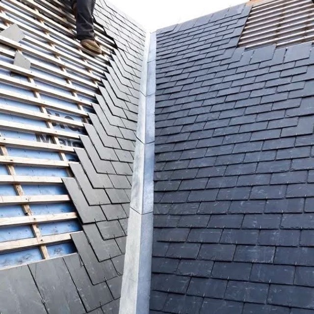 Roofer installing slate with a lead valley